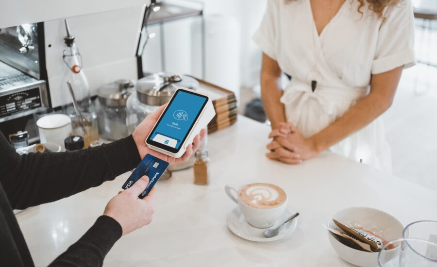 woman at cafe using instant approval credit card