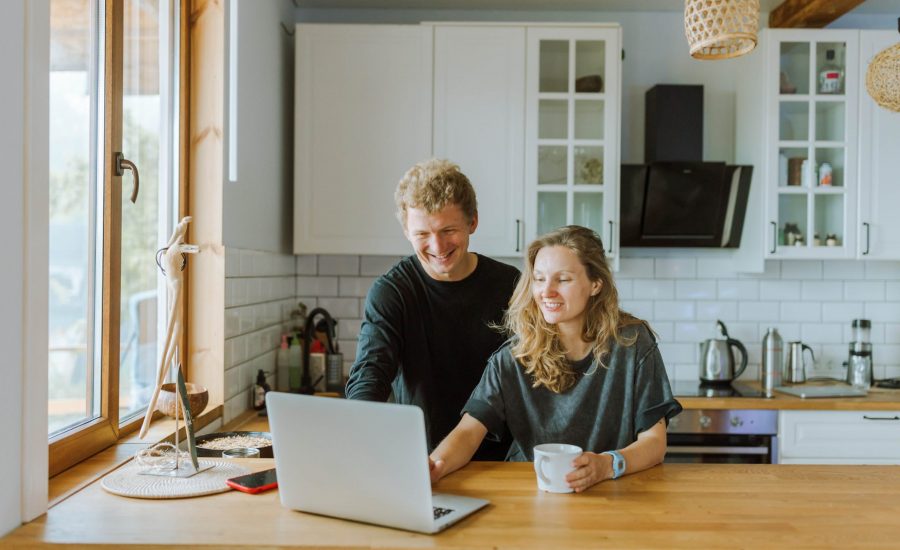 couple consulting laptop computer in their kitchen