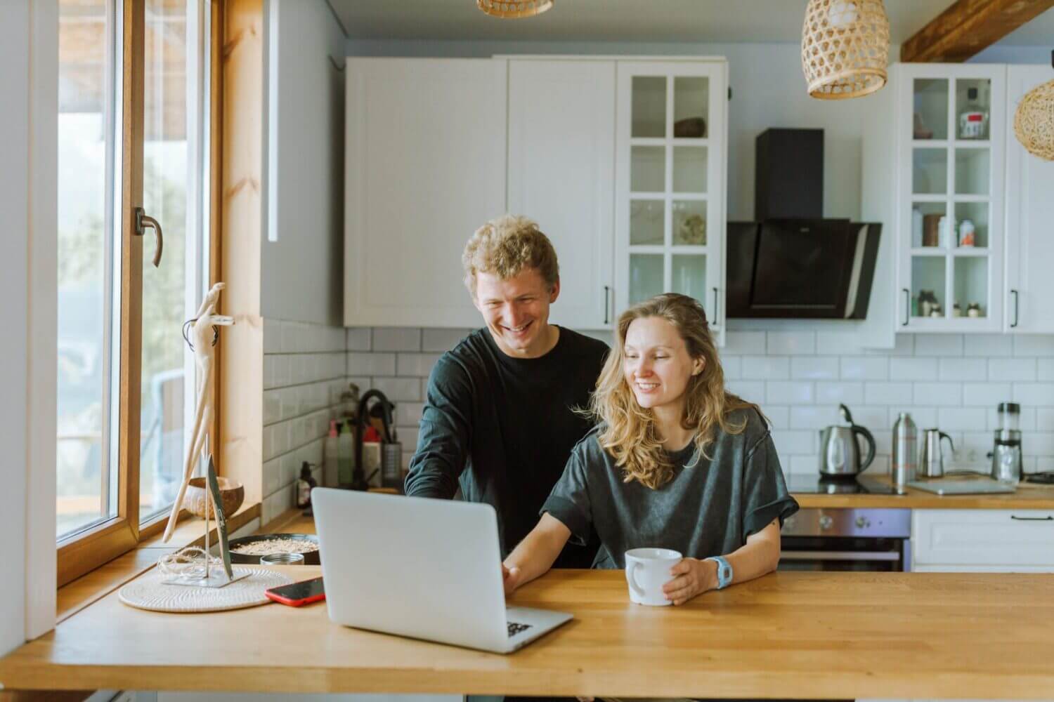 couple consulting laptop computer in their kitchen