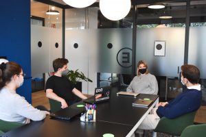 masked colleagues meet in coworking space