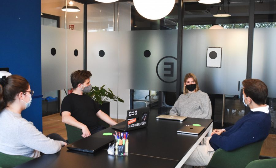 masked colleagues meet in coworking space