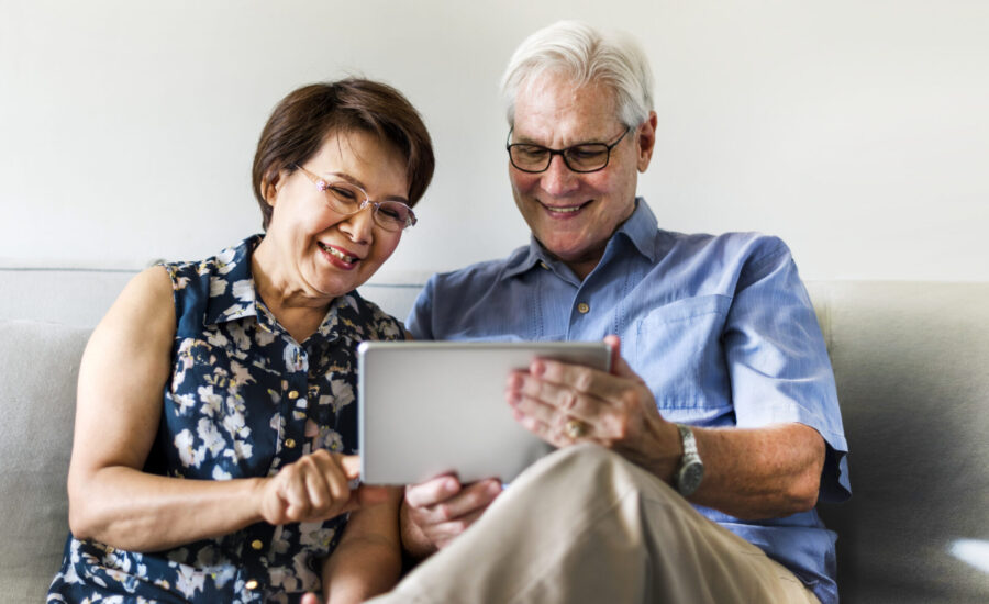 Senior couple using a digital device in a living room