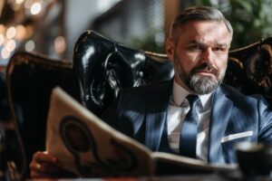 grey-haired man sitting in leather armchair