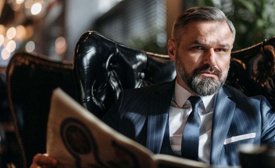 grey-haired man sitting in leather armchair