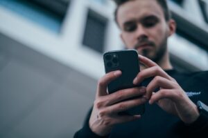 Man looking at phone for how to buy cardano in Canada