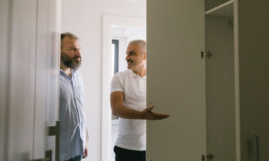 Two men looking around an empty room that's ready to be moved into.