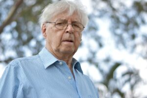 white-haired man standing outdoors