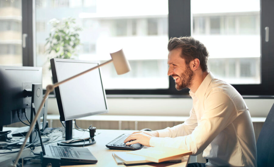 A man enthusiastically looking at his computer. It must be good news.