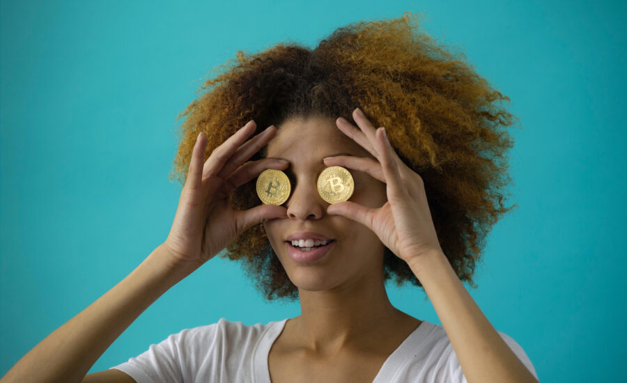 A woman is seen holding two coins to her eyes