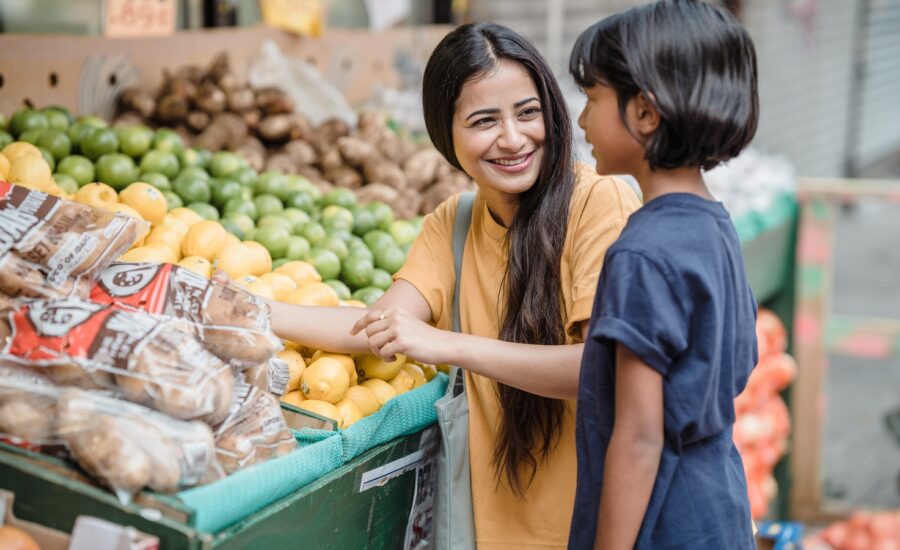 A woman and young girl shop for fresh produce.