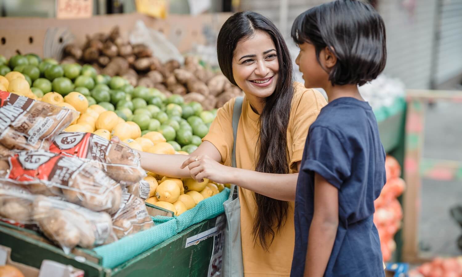 A woman and young girl shop for fresh produce.
