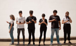 A group of teenagers all on their cellphones, checking their investments, we hope.