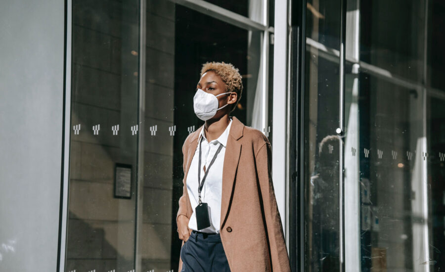 A masked woman is seen walking down a street