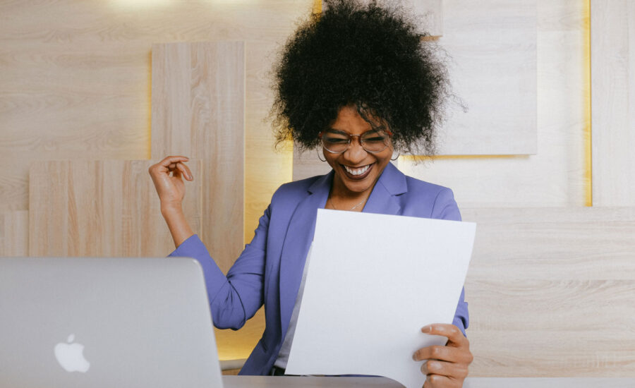 A happy woman reading her ETF returns, while sitting at her work-at-home desk