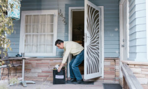 A man opens his door to find a bag of fresh food has been delivered to his front door.