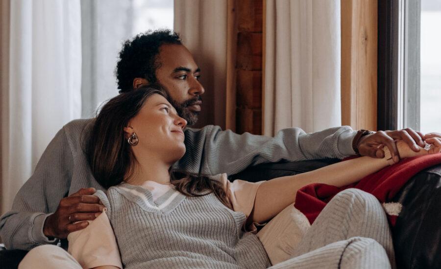 A couple sitting on their couch enjoying their home, as they look out the windwo