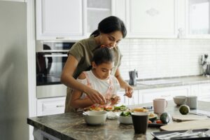 5 money fears from childhood and how to overcome them mother and daughter cooking in kitchen