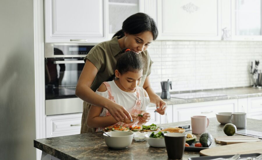 5 money fears from childhood and how to overcome them mother and daughter cooking in kitchen