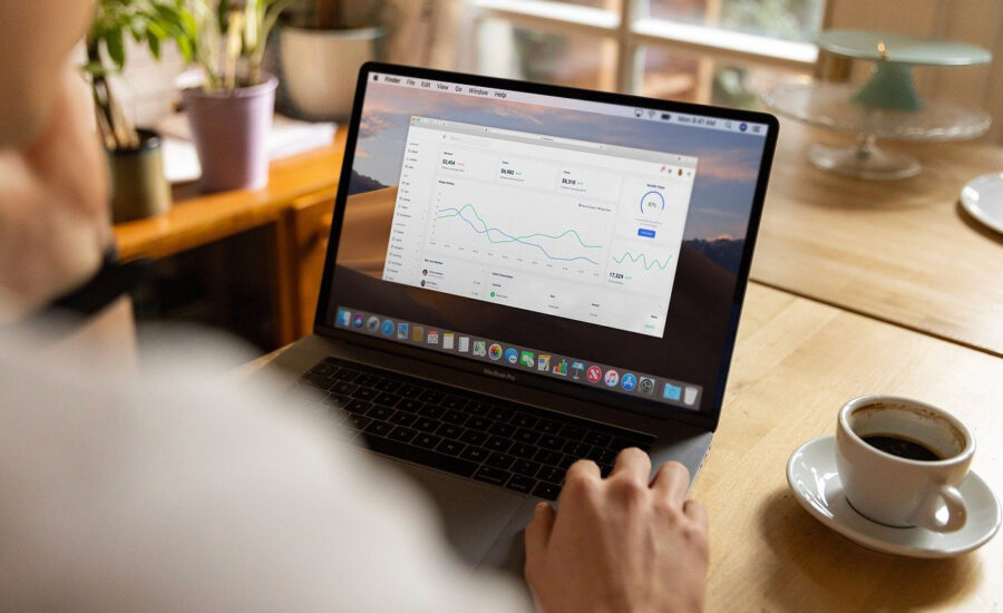 A person is seem sitting at a table working on a laptop