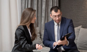 A woman and a man are interpreting the performance of her investments on a tablet