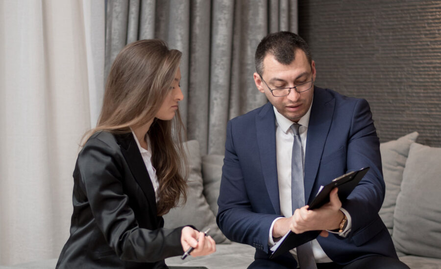 A woman and a man are interpreting the performance of her investments on a tablet