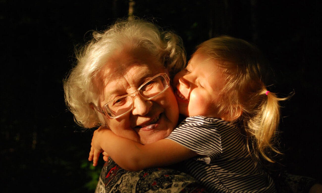 A grandmother hugs her grandchild in the early morning