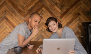 Two people looking at a computer with mixed emotions as they've just filed their returns