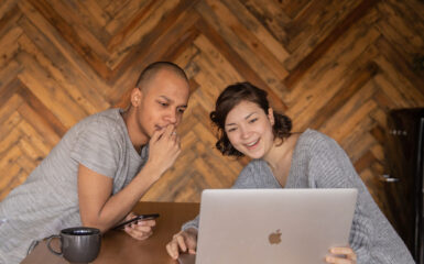 Two people looking at a computer with mixed emotions as they've just filed their returns