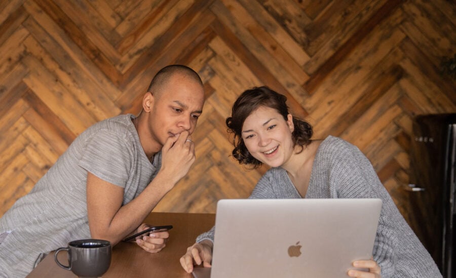 Two people looking at a computer with mixed emotions as they've just filed their returns