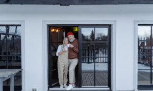 A senior-age couple outside their house