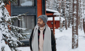 Playing on the words "all-weather" a man is walking outside in the snow, fully dressed and ready for the weather.