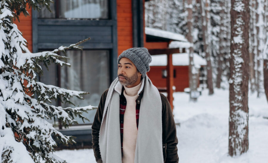 Playing on the words "all-weather" a man is walking outside in the snow, fully dressed and ready for the weather.