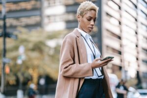 business woman walking looking at smartphone