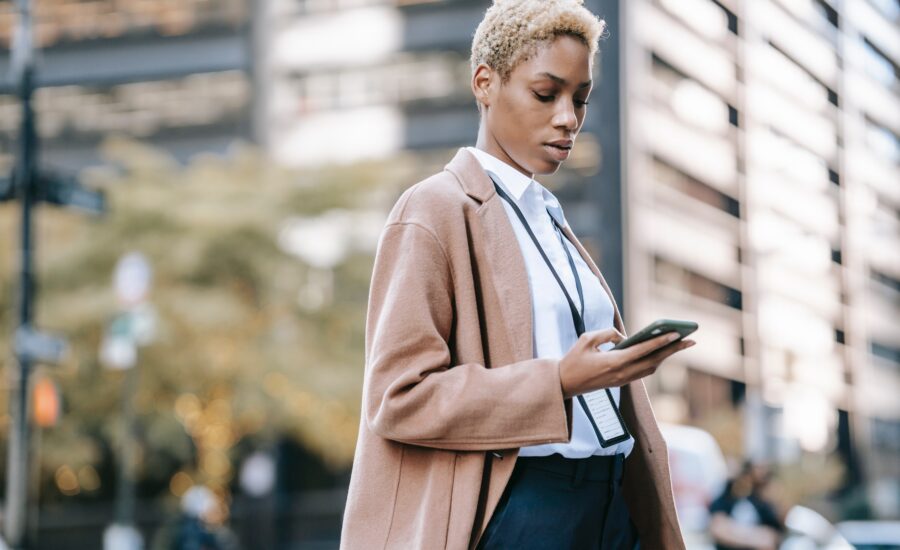 business woman walking looking at smartphone