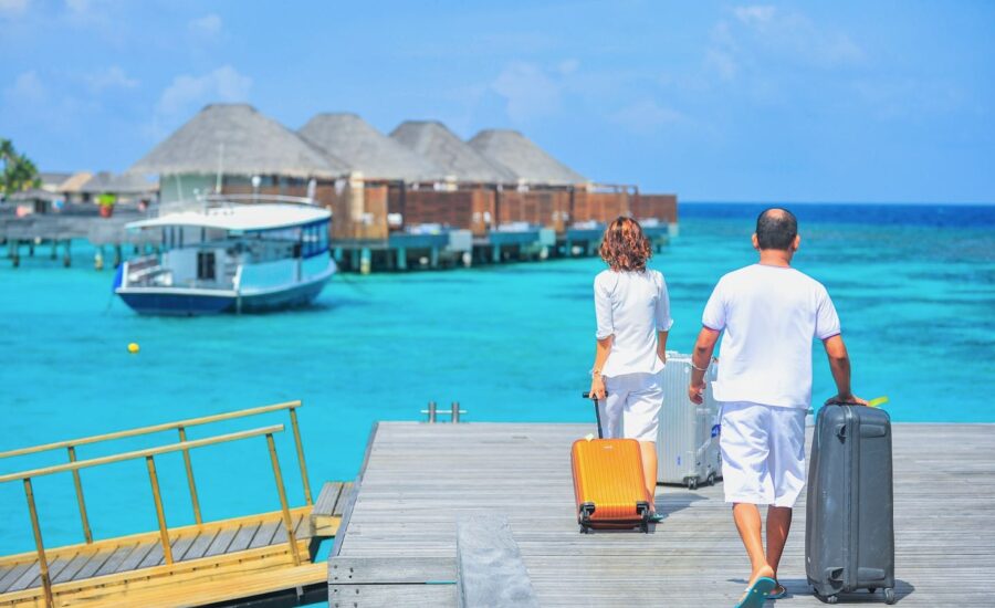 Two people are seen walking on a dock towards a lake