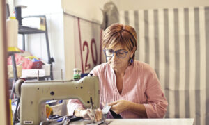 A woman in her retirement years sitting at a sewing machine