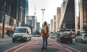 A woman who used the TD First Class Visa Infinite to book travel walks on a busy city street.