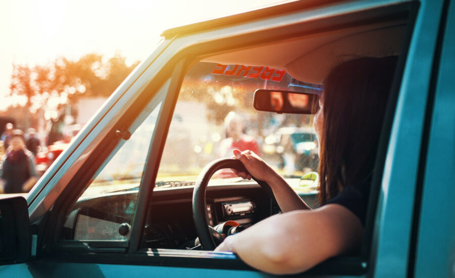 A woman sits in her vehicle with the window down