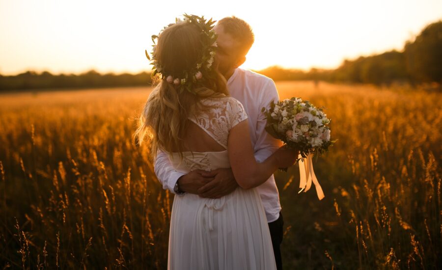 bride and groom stand in field after microwedding