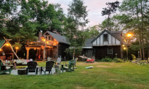 A backyard with a fire pit and chairs in the summer