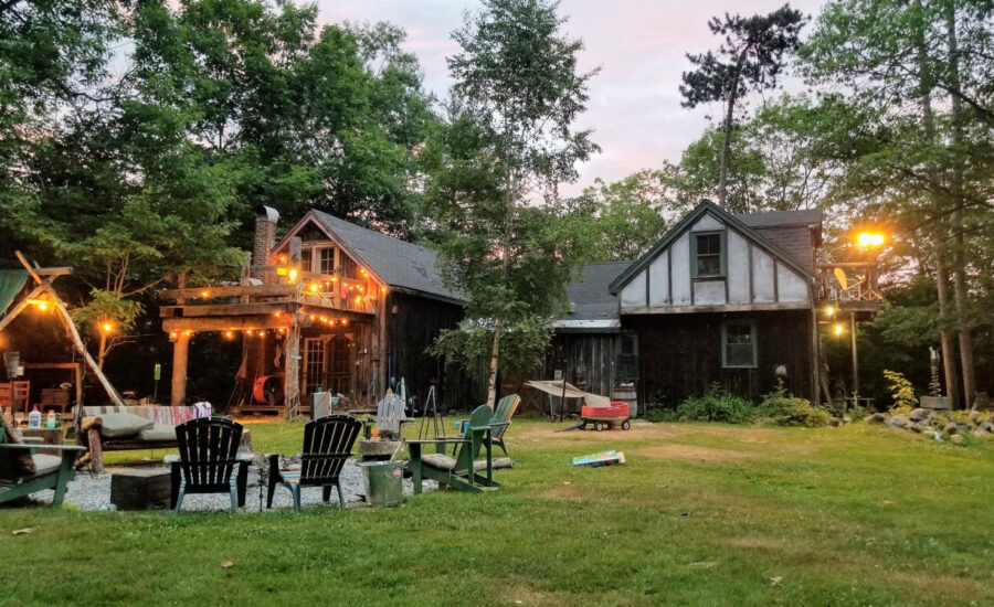 A backyard with a fire pit and chairs in the summer