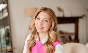 Jessica Moorhouse is smiling as she sits in a sunlit office.