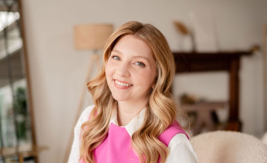 Jessica Moorhouse is smiling as she sits in a sunlit office.