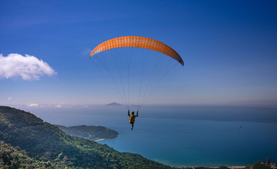 A photo of someone floating in the air above mountains, symbolizing the risk of investing and the safety of bonds.