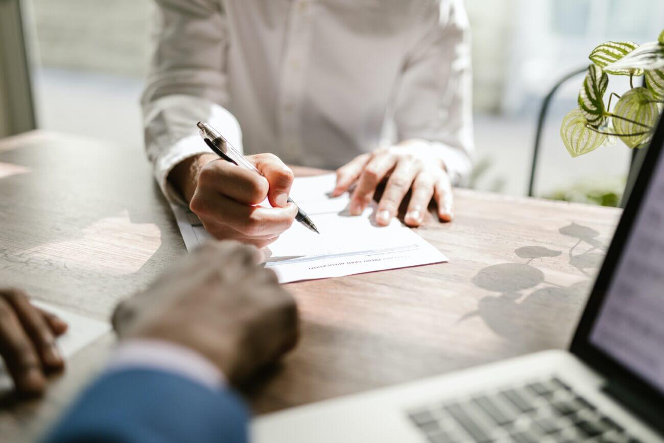 a woman cosigns on a loan in a sunny office