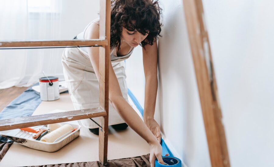 A woman prepares a wall to be painted