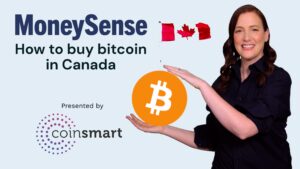 A woman stands holding the bitcoin logo between her hands