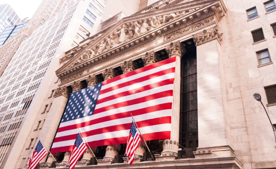 The outside of the NYSE, standing proud and tall, completely decorated with American flags.