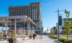 A woman walks towards a new high-rise building in downtown Markham, Ont.