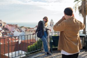 a woman on vacation poses for a picture with scenery behind her